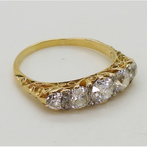 2756 - A FIVE STONE RINGin classic yellow metal scroll mount, set with five old cut diamonds with a combine... 