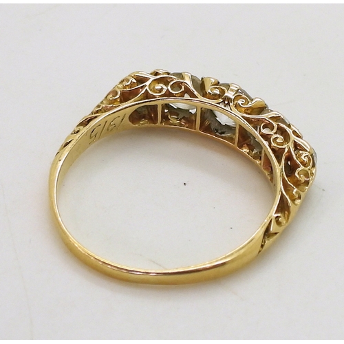 2756 - A FIVE STONE RINGin classic yellow metal scroll mount, set with five old cut diamonds with a combine... 