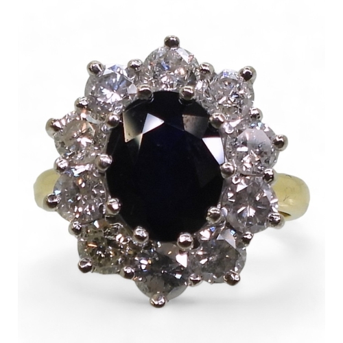 2765 - A SUBSTANTIAL CLUSTER RING,set with a 9.5mm x 7.5mm x 4.7mm oval cut sapphire, surrounded with estim... 