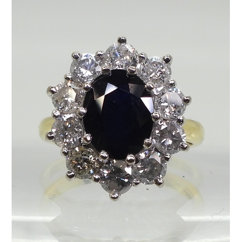 2765 - A SUBSTANTIAL CLUSTER RING,set with a 9.5mm x 7.5mm x 4.7mm oval cut sapphire, surrounded with estim... 