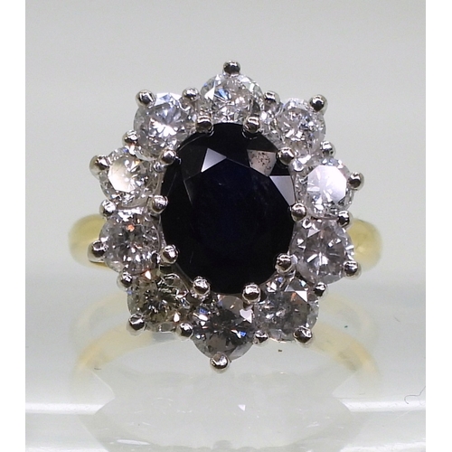 2765 - A SUBSTANTIAL CLUSTER RING,set with a 9.5mm x 7.5mm x 4.7mm oval cut sapphire, surrounded with estim... 