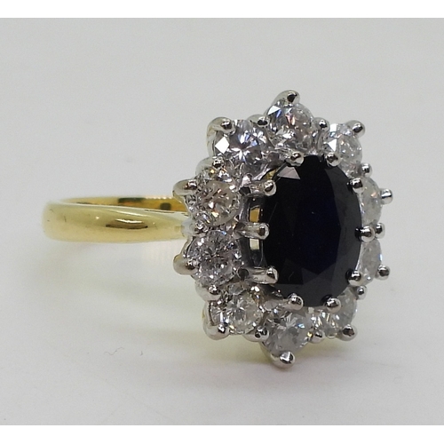 2765 - A SUBSTANTIAL CLUSTER RING,set with a 9.5mm x 7.5mm x 4.7mm oval cut sapphire, surrounded with estim... 