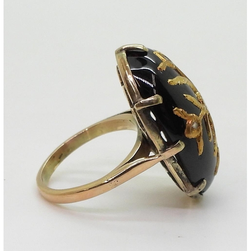 766 - A yellow metal ring set with an earlier garnet carbuncle with inset gold foliage with rose cut diamo... 