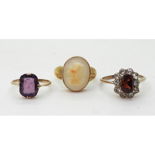 769 - A 9ct gold cameo ring, size N, a 9ct purple glass ring, size J1/2, and a yellow metal garnet and cle... 