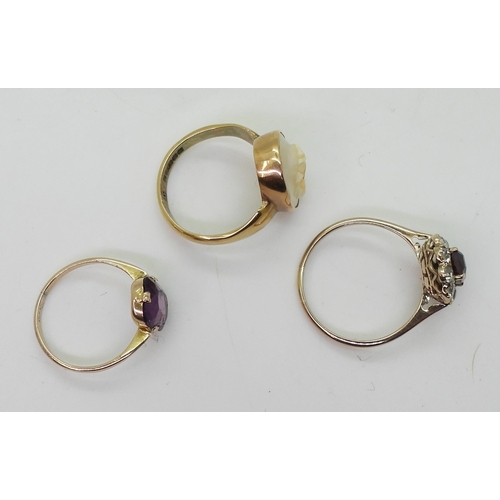 769 - A 9ct gold cameo ring, size N, a 9ct purple glass ring, size J1/2, and a yellow metal garnet and cle... 