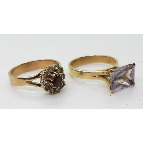 775 - A yellow metal ring set with a fancy cut amethyst, size K, together with a garnet and clear gem set ... 