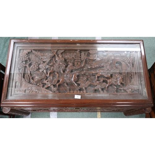 70 - A 20th century Chinese camphorwood blanket chest carved with stylized battle scenes to top and front... 