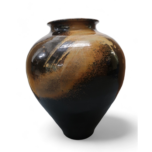 2322 - ALICE MACFARLANEAn oversized studio pottery vase of bulbous tapering form, in brown and tan glaze, 8... 