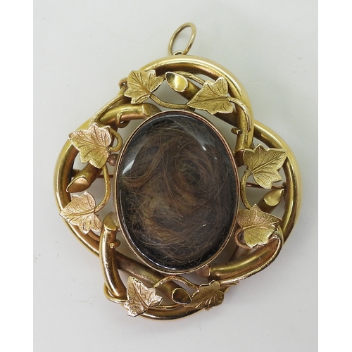 2794 - AN IVY LEAF MOURNING PENDANT/BROOCHmade in bright yellow metal, with two locket compartments filled ... 