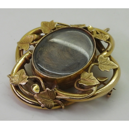 2794 - AN IVY LEAF MOURNING PENDANT/BROOCHmade in bright yellow metal, with two locket compartments filled ... 