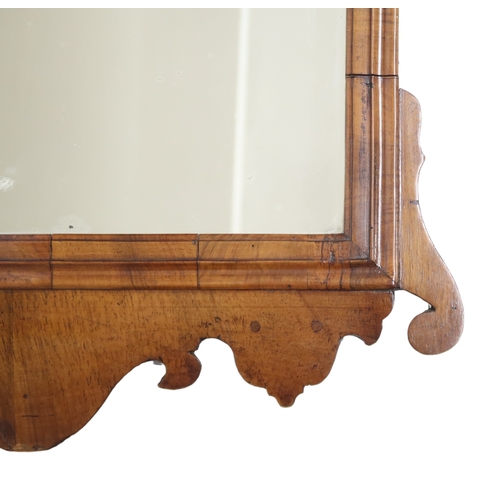 2004 - A GEORGIAN WALNUT VENEERED WALL MIRRORwith fret cut scrolled frame, 94cm high x 55cm wide... 