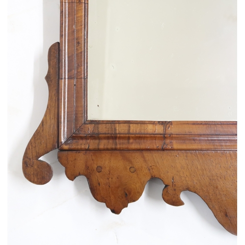 2004 - A GEORGIAN WALNUT VENEERED WALL MIRRORwith fret cut scrolled frame, 94cm high x 55cm wide... 