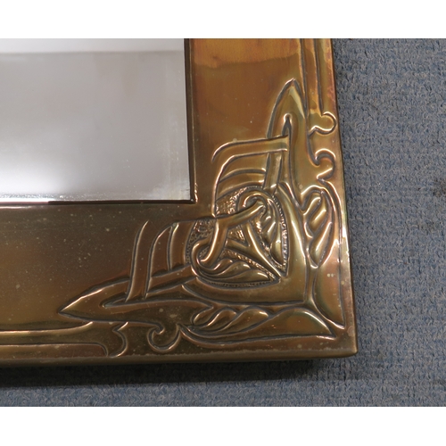 2243 - A SCOTTISH SCHOOL BRASS FRAMED MIRRORwith central repousse decoration of a ship, with celtic knotwor... 