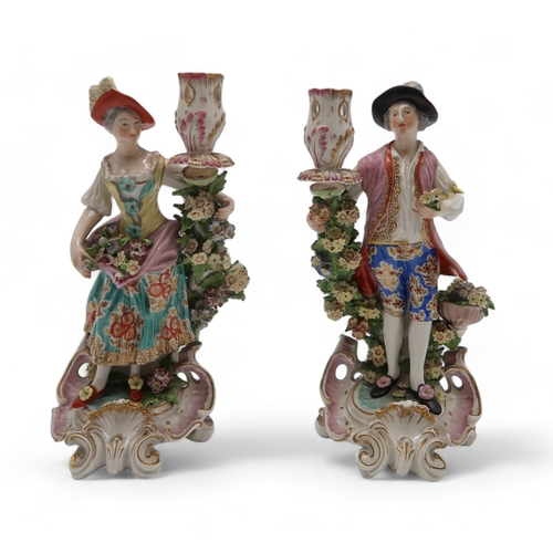 2252 - A PAIR OF DERBY PORCELAIN FIGURAL CANDLESTICKSmodelled as a woman with a floral dress holding flower... 