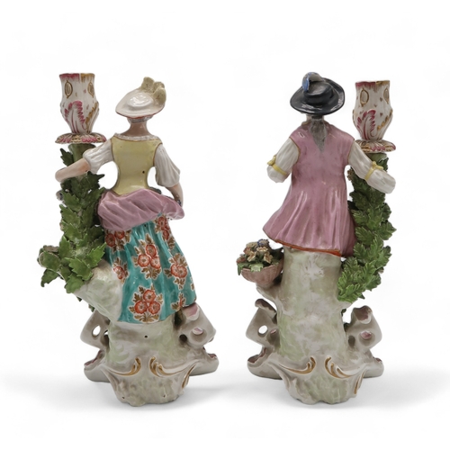 2252 - A PAIR OF DERBY PORCELAIN FIGURAL CANDLESTICKSmodelled as a woman with a floral dress holding flower... 