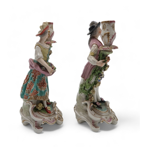 2252 - A PAIR OF DERBY PORCELAIN FIGURAL CANDLESTICKSmodelled as a woman with a floral dress holding flower... 