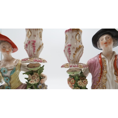 2252 - A PAIR OF DERBY PORCELAIN FIGURAL CANDLESTICKSmodelled as a woman with a floral dress holding flower... 