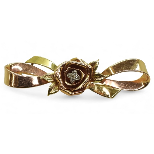 2812 - A 14K TRICOLOUR GOLD BROOCHwith rose motif in rose gold the centre set with diamond accents. Length ... 