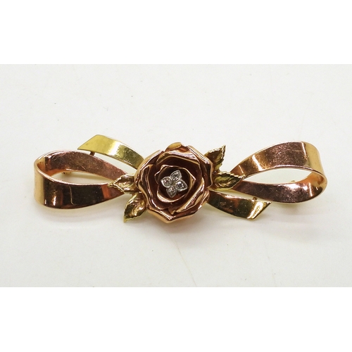 2812 - A 14K TRICOLOUR GOLD BROOCHwith rose motif in rose gold the centre set with diamond accents. Length ... 