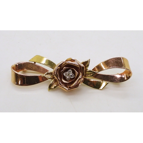 2812 - A 14K TRICOLOUR GOLD BROOCHwith rose motif in rose gold the centre set with diamond accents. Length ... 