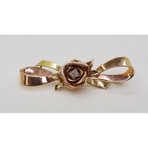 2812 - A 14K TRICOLOUR GOLD BROOCHwith rose motif in rose gold the centre set with diamond accents. Length ... 