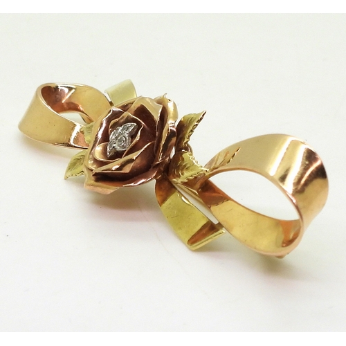 2812 - A 14K TRICOLOUR GOLD BROOCHwith rose motif in rose gold the centre set with diamond accents. Length ... 