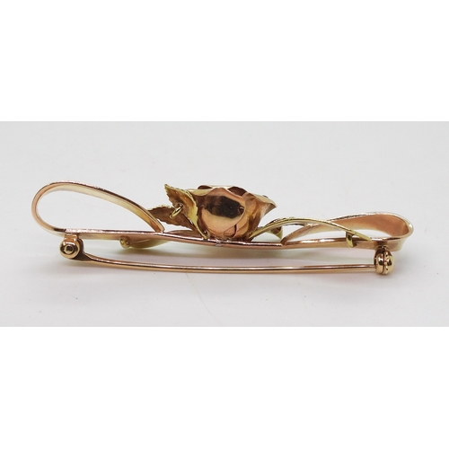 2812 - A 14K TRICOLOUR GOLD BROOCHwith rose motif in rose gold the centre set with diamond accents. Length ... 