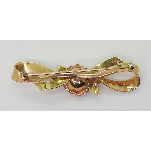 2812 - A 14K TRICOLOUR GOLD BROOCHwith rose motif in rose gold the centre set with diamond accents. Length ... 