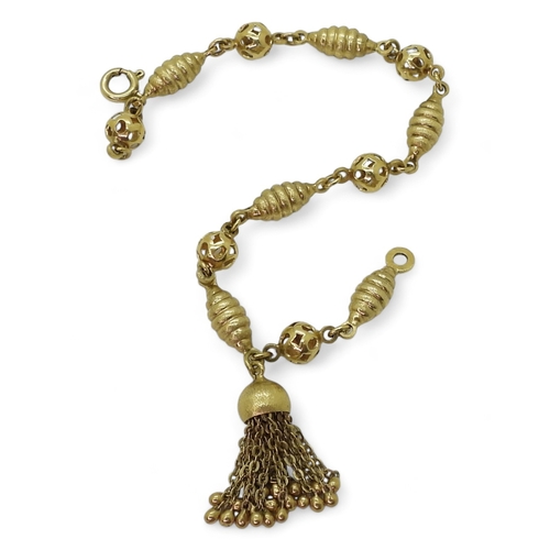 2819 - AN 18CT FANCY BEAD BRACELETwith alternate twist and pierced beads, with a tassel detail, stamped 750... 