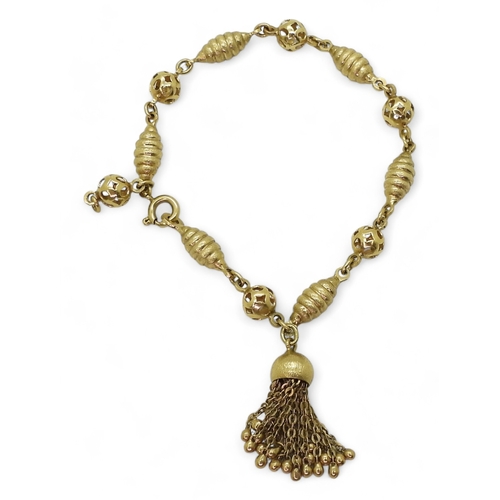 2819 - AN 18CT FANCY BEAD BRACELETwith alternate twist and pierced beads, with a tassel detail, stamped 750... 