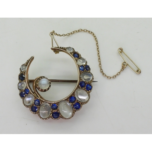 2831 - A CRESCENT BROOCHset with moonstone & blue paste to the yellow metal galleried mount, diameter a... 