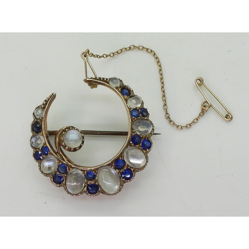 2831 - A CRESCENT BROOCHset with moonstone & blue paste to the yellow metal galleried mount, diameter a... 