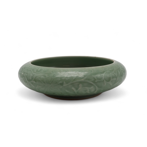 2405 - A CHINESE CELADON BOWLthe inner carved with a dragon and the outer carved with a ruyi band above mea... 