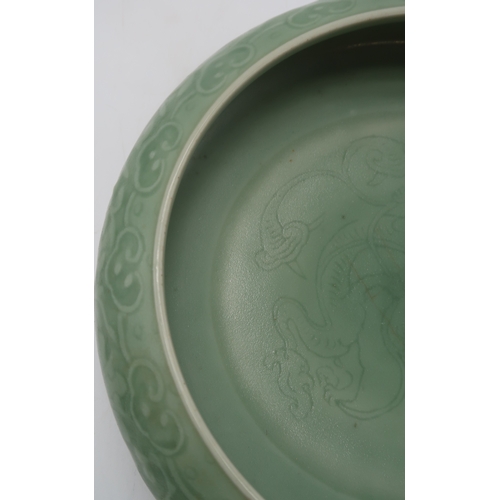 2405 - A CHINESE CELADON BOWLthe inner carved with a dragon and the outer carved with a ruyi band above mea... 