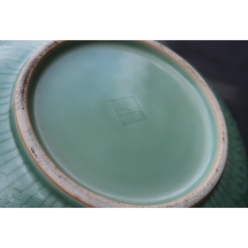 2405 - A CHINESE CELADON BOWLthe inner carved with a dragon and the outer carved with a ruyi band above mea... 