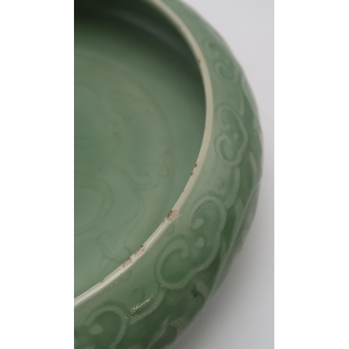 2405 - A CHINESE CELADON BOWLthe inner carved with a dragon and the outer carved with a ruyi band above mea... 