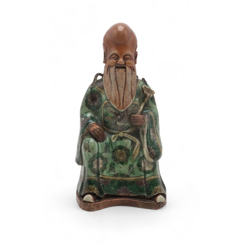 2407 - A CHINESE FAMILLE VERTE MODEL OF SHOULAOseated with ruyi sceptre and wearing floral patterned robes,... 