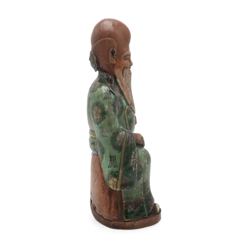 2407 - A CHINESE FAMILLE VERTE MODEL OF SHOULAOseated with ruyi sceptre and wearing floral patterned robes,... 