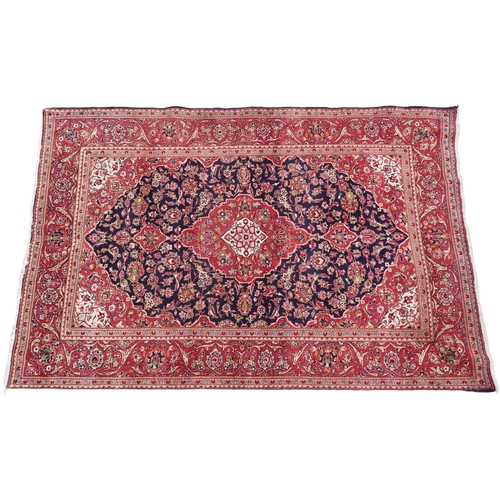 2124 - A DARK BLUE GROUND KESHAN RUG with terracotta and cream diamond form central medallion and matc... 