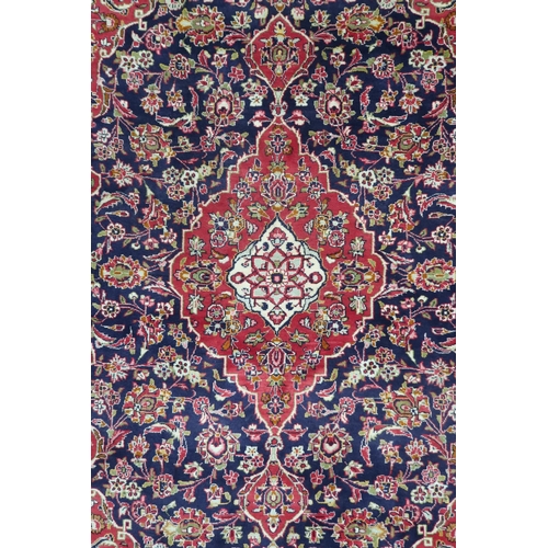 2124 - A DARK BLUE GROUND KESHAN RUG with terracotta and cream diamond form central medallion and matc... 