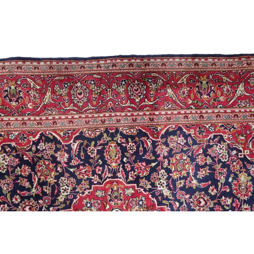 2124 - A DARK BLUE GROUND KESHAN RUG with terracotta and cream diamond form central medallion and matc... 