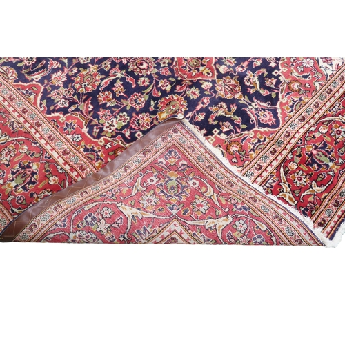 2124 - A DARK BLUE GROUND KESHAN RUG with terracotta and cream diamond form central medallion and matc... 