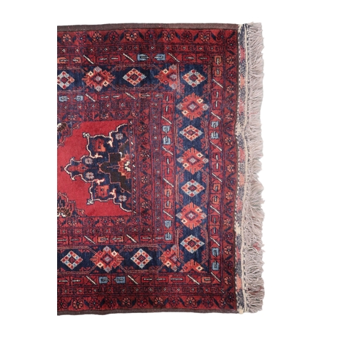 2125 - A RED GROUND FINE AFGHAN RUNNER with multiple dark medallions with multicoloured geometric bord... 