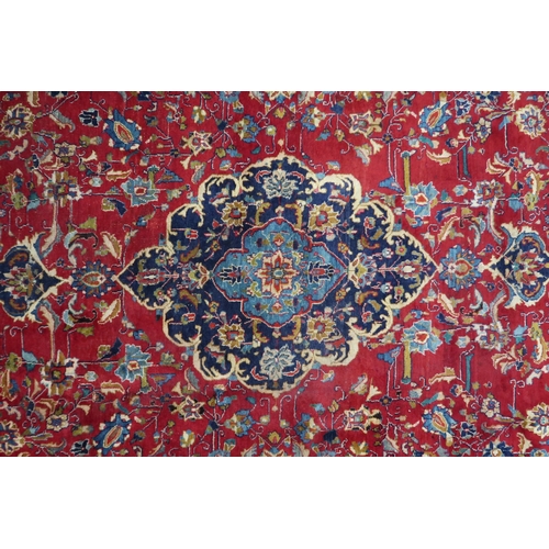 2126 - A LARGE RED GROUND TRADITIONAL PERSIAN MASHED RUG with light & dark blue central medallion ... 