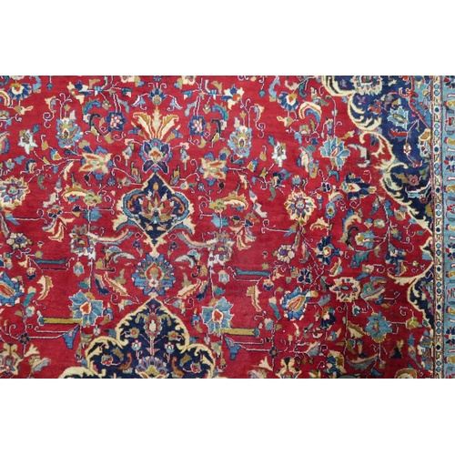 2126 - A LARGE RED GROUND TRADITIONAL PERSIAN MASHED RUG with light & dark blue central medallion ... 