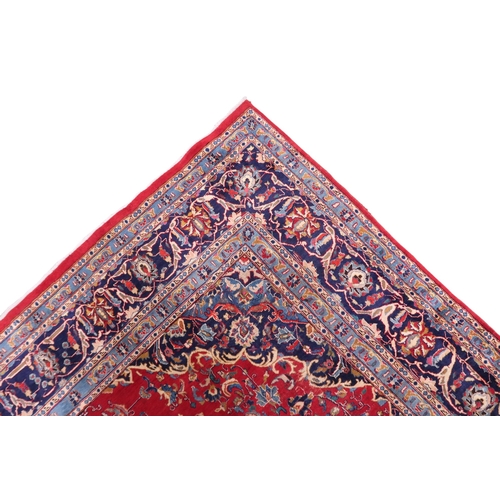 2126 - A LARGE RED GROUND TRADITIONAL PERSIAN MASHED RUG with light & dark blue central medallion ... 