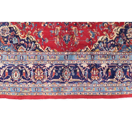 2126 - A LARGE RED GROUND TRADITIONAL PERSIAN MASHED RUG with light & dark blue central medallion ... 