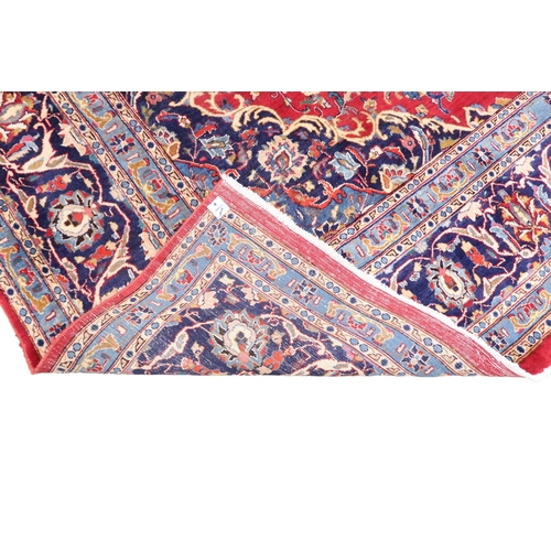 2126 - A LARGE RED GROUND TRADITIONAL PERSIAN MASHED RUG with light & dark blue central medallion ... 