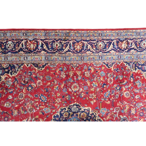 2126 - A LARGE RED GROUND TRADITIONAL PERSIAN MASHED RUG with light & dark blue central medallion ... 