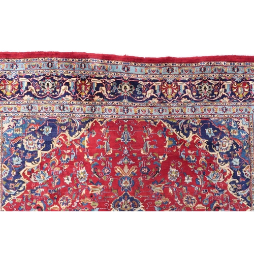 2126 - A LARGE RED GROUND TRADITIONAL PERSIAN MASHED RUG with light & dark blue central medallion ... 